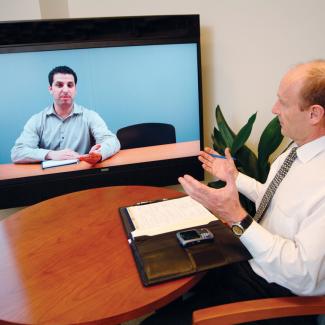 Video Conference Equipment with two people meeting using a monitor